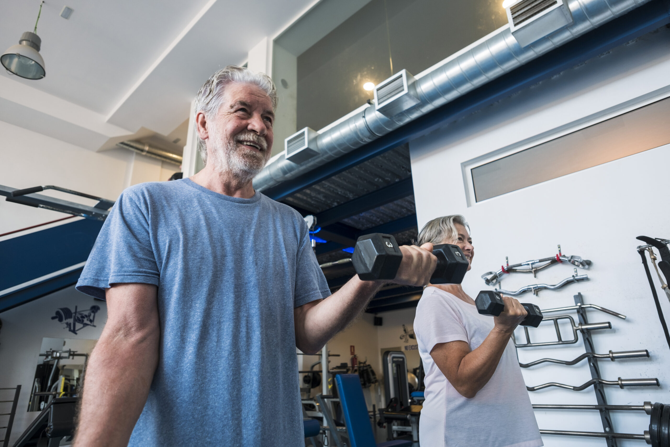 couple of two seniors and mature people at the gym doing exercis